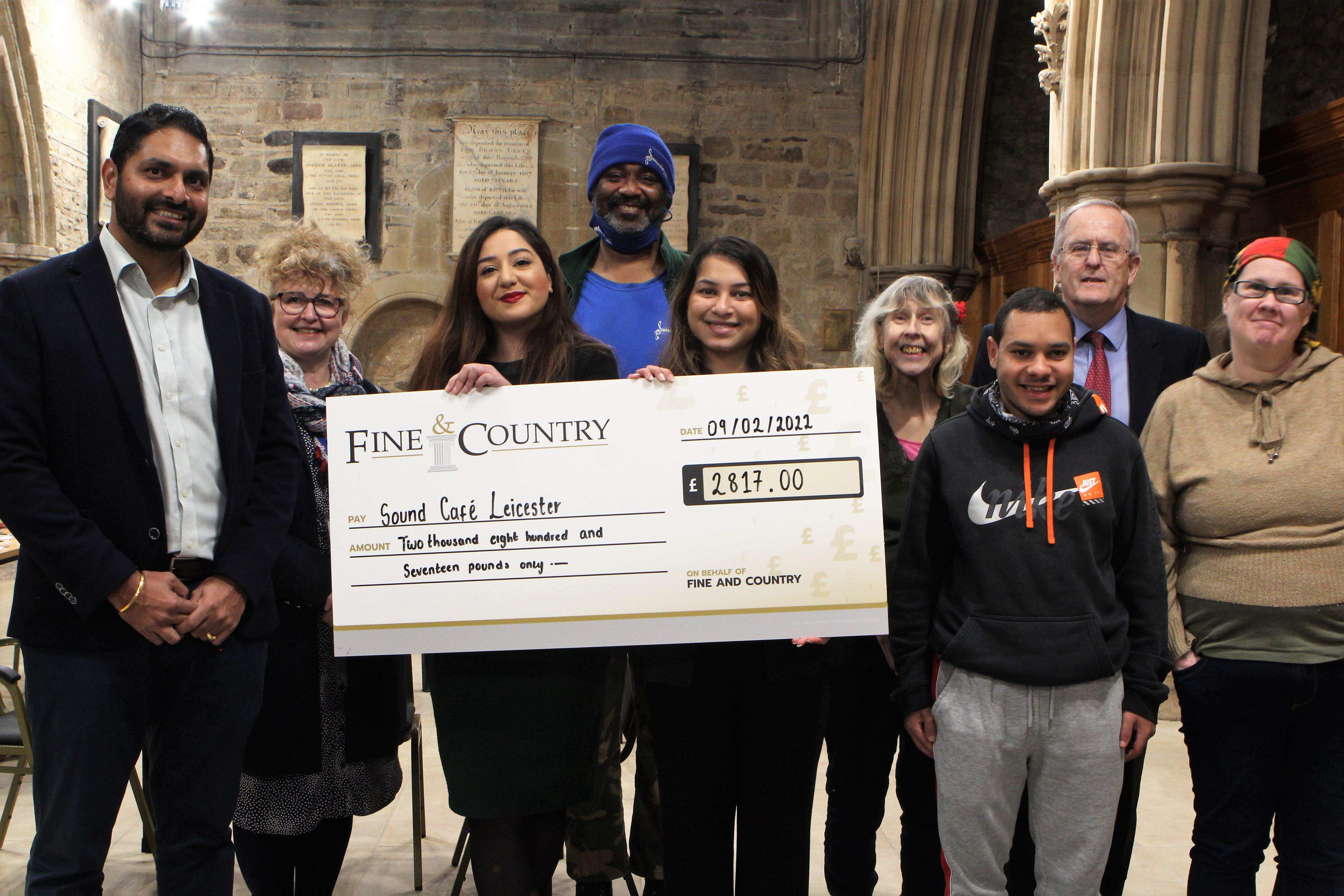SoundCafe receiving a cheque from supporters
